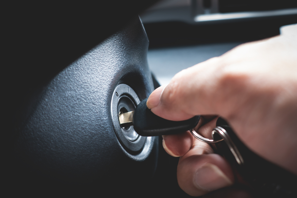 Hand inserting a car key into the ignition, illustrating key extraction and ignition repair services by Swift Locksmith in Raleigh, NC.
